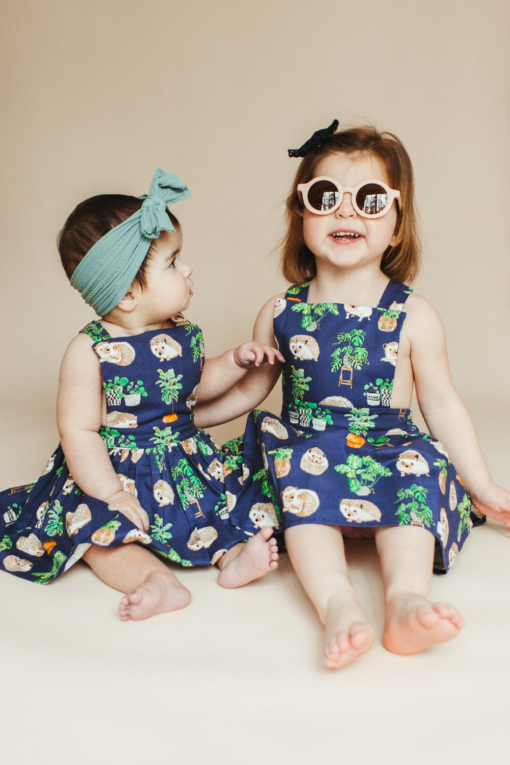 baby and toddler in pinafore dress